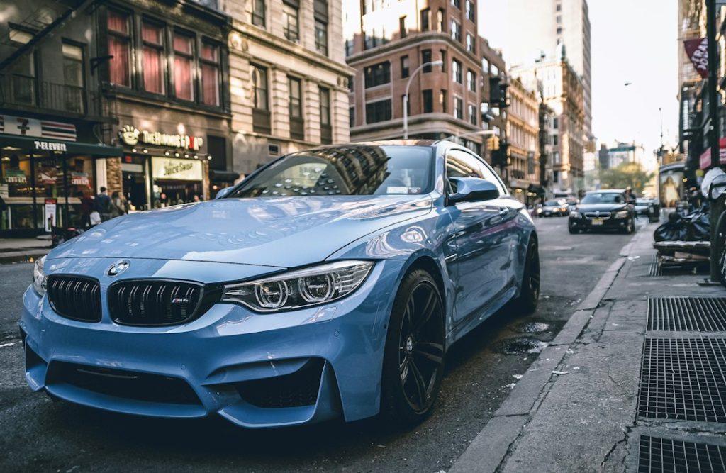 Синьо спортно BMW, паркирано на път